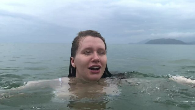 Young scared frightened woman having panic attack, drown in water, phobia in the sea