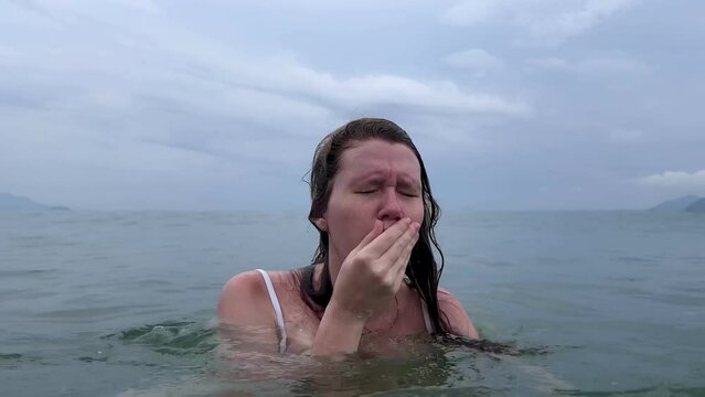 Young scared frightened woman having panic attack, drown in water, phobia in the sea
