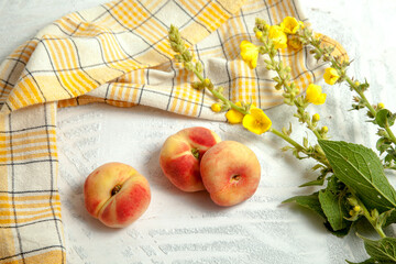 Three saturn peaches or flat peach on white wooden background..