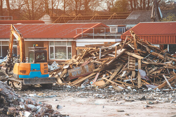 Fototapeta premium Demolition of building. Excavator breaks old house. 