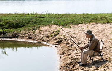 Adult middle aged man fishing in the lake