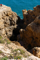 Algar Seco in Carvoeiro. Beautiful Golden Sandstone Rock Formation in Algarve with Atlantic Ocean in the Distance. Rocks, rocky shore, yellow rocks, coquina, beautiful coastline