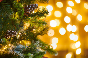 Festive New Year Christmas tree with pine cone decorations with garlands lights, close up view copy...