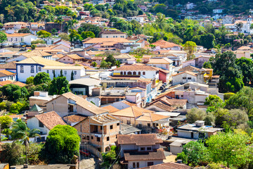 Partial view of the city of Sabará, Brazil. Streets, bridge, mountain, trees and blue sky with clouds.
