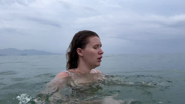 Young scared frightened woman having panic attack, drown in water, phobia in the sea