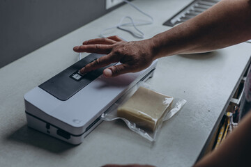 man vacuum-packing cheese with a vacuum cleaner