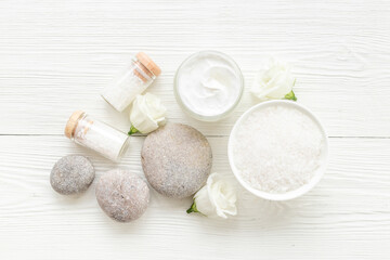Layout of white cosmetics products and roses flowers, top view