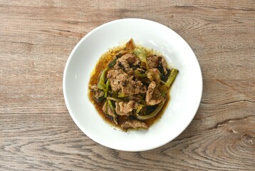 spicy stir fried slice pork meat with onion and sweet chili couple black pepper on plate 