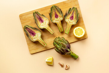 Raw artichoke flower buds with garlic, cooking background