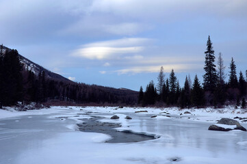 Icy river in a winter wonderland under a cloudy sky