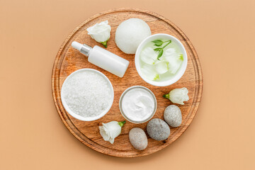 Tray on bathroom table with skin care cosmetics and white roses