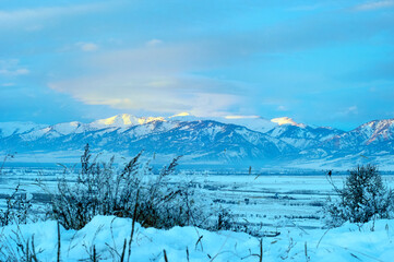 Cold snowy mountain landscape at sunset.