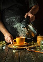 A man adds boiling water to a mug to make medicinal tea in the kitchen. Traditional medicine concept or making healthy tea from medicinal dry plants