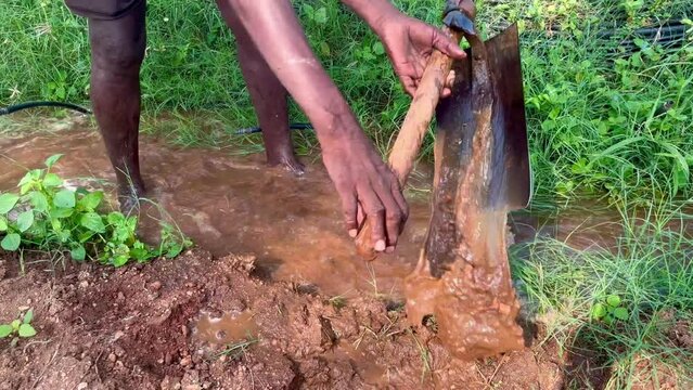 Farmer digging in the agriculture field for the free flow of water