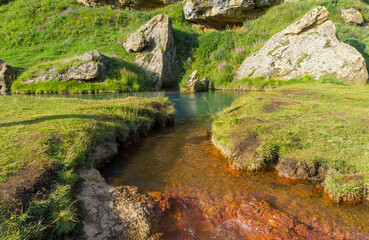 A mineral spring flows into Abano lake. The brown red color of the salt and azure color of the lake