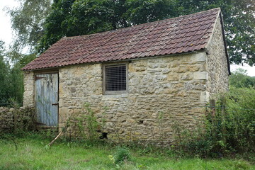 Exterior view of an old derelict stone barn in the English countryside - travel and architecture...