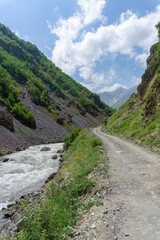 Stream of the Terek River and gravel road at the bottom of the gorge