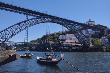 Obraz premium View of the Douro River and the bridge over it -Ponte Dom Luis 1- which connects the cities of Porto and Vila Nova de Gaia. The bridge is a UNESCO World Heritage Site