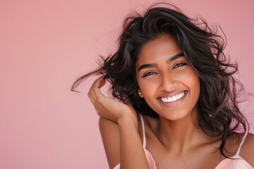 Young beautiful indian woman smiling on pink background