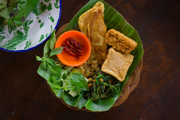 Traditional Indonesian side dish with tempeh, tofu, omelet, basil leaves and hot chili sauce