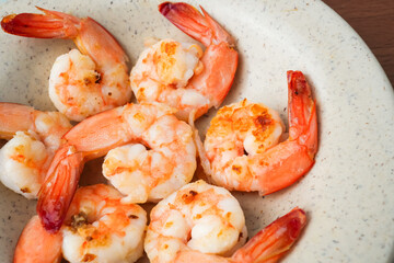 Close up photo of Grilled shrimp without skin served on a small plate and placed on the wooden table. Concept for whole natural protein and omega-3.