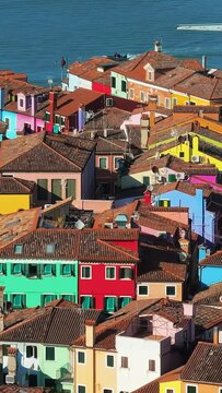 Aerial drone view of the colourful houses of Burano Island, Italy. Vertical