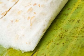 Traditional tempeh wrapped in banana leaves. Tempeh is a traditional Indonesian food made from fermented soybeans and special yeast mold. Concept for vegetable protein and plant based food.