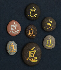 Chinese character xi or Japanese iki, meaning rest, written on pebble