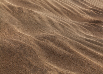 natural sand pattern created by wind blowing differently sized and colored particles