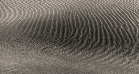 natural sand pattern created by wind blowing differently sized and colored particles
