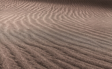natural sand pattern created by wind blowing differently sized and colored particles