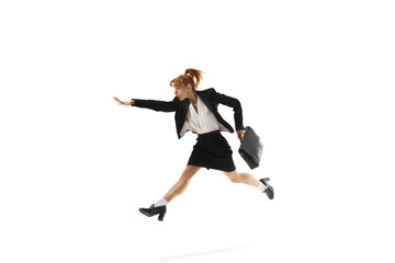 Fototapeta na wymiar Ambitious young woman, employee on formal wear, with briefcase in dynamic pose, running forward isolated on white background. Reaching professional growth. Business, office lifestyle, success concept