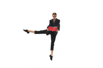 Businesswoman in formal wear emotionally looking on book, notes, standing in mid-air pose isolated on white background. Professional challenges. Concept of business, office lifestyle, human emotions