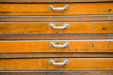Old magazine close-up. Wooden chest with many drawers.
