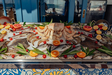 sea food on outside store counter. Fish and crab on ice decorated with fresh citrus fuit