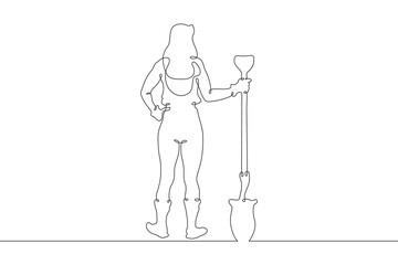 A woman in work clothes digs with a shovel. The female farmer is digging. A gardener works on the...