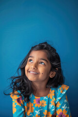 Indian little girl giving happy expression on blue background