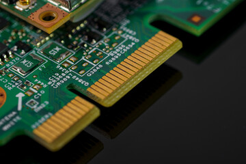 Green circuit board with gold connectors and labeled components.