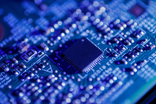 Green circuit board with a black integrated circuit chip and various small electronic components