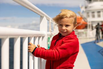 Children, experience ride with ferry on a fjord, strong wind on the deck of the ferry on sunny day