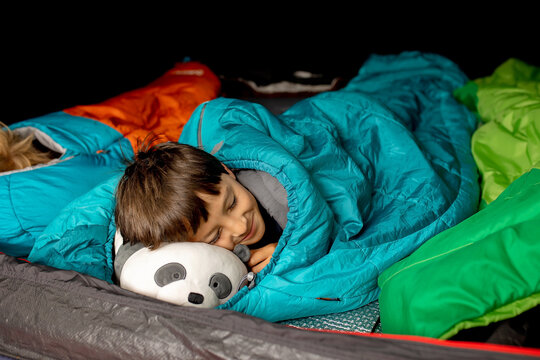 Children, sibilngs, sleeping in sleeping bags in a tent in Norway