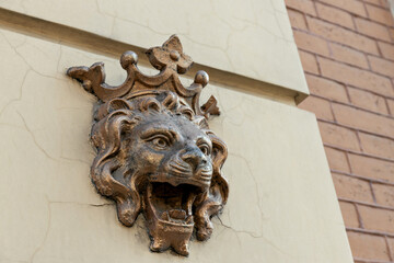 A lion with a crown on a house, on the street.