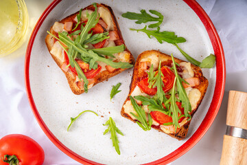 Tasty crunchy toasts pizza. Fast food, modern variation of portioned quick made pizza on toast bread with tomato, bacon, mozzarella cheese and arugula, copy space