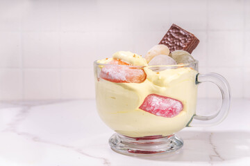 Mochi parfait trendy asian dessert, ice cream parfait layered with fruit, berry, sweets and various mochi. Summer frozen sweet snack in portioned cup, copy space