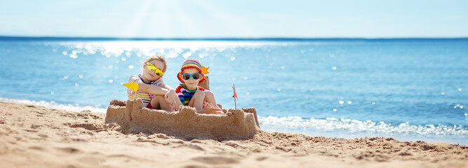 Boy and girl building on the beach sandcastle. Family vacation and tourism concept.