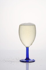 Eingiessen von Weisswein in Glas, übergelaufen