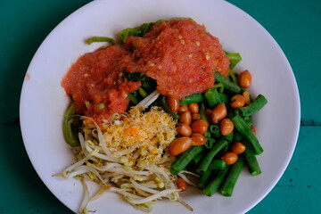 Plecing kangkung is a typical Indonesian dish originating from Bali and Lombok. Plecing kangkung consists of boiled water spinach and served cold and fresh with tomato sauce, cayenne pepper, salt. 