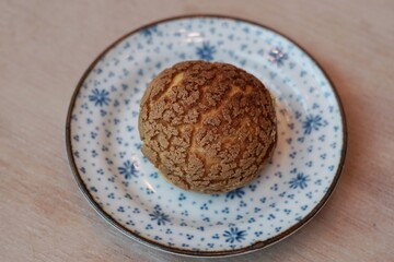 A choux cream puff bakery pastry on the plate.
