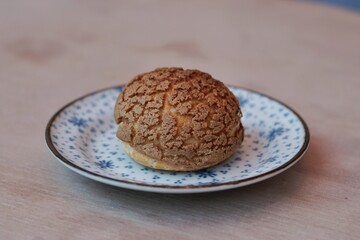 A choux cream puff bakery pastry on the plate.