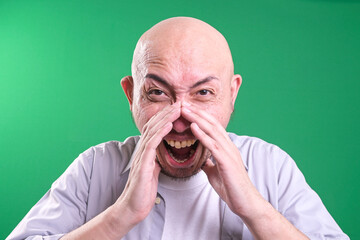 Bald man shouting and cupping hands around mouth